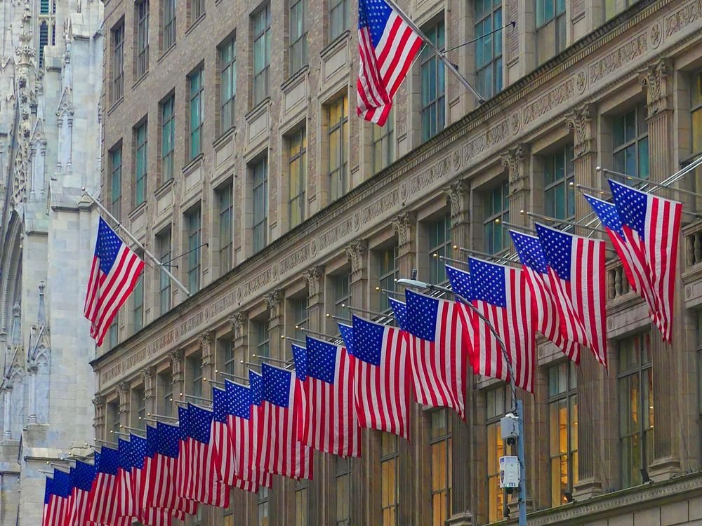 Bandeiras dos Estados Unidos na fachada de um prédio em Nova York