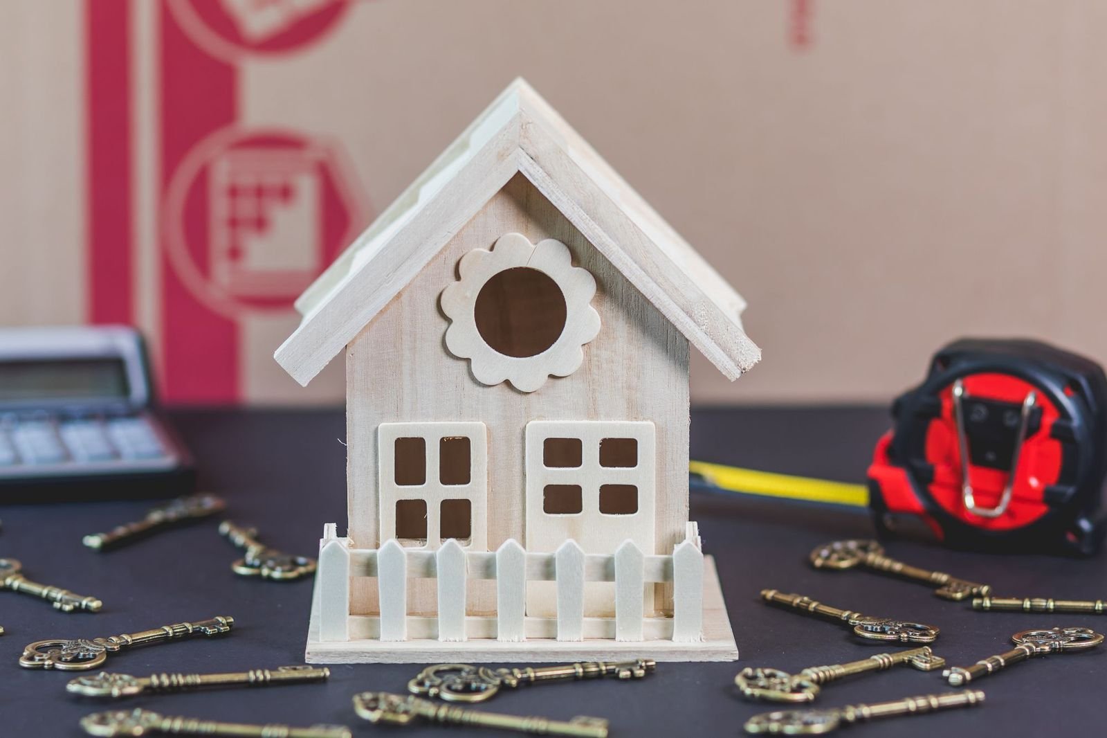 Casa em miniatura cercada de chaves antigas sobre a mesa