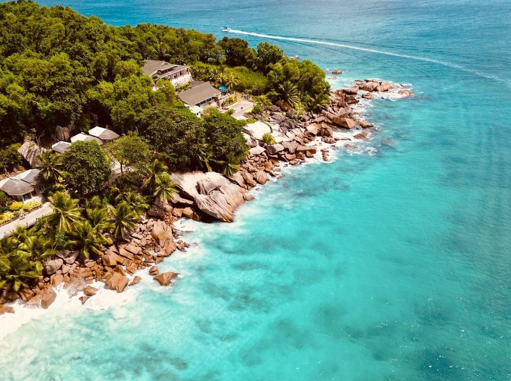 Vista aérea do litoral de Seychelles, com mar azul-turquesa e mata